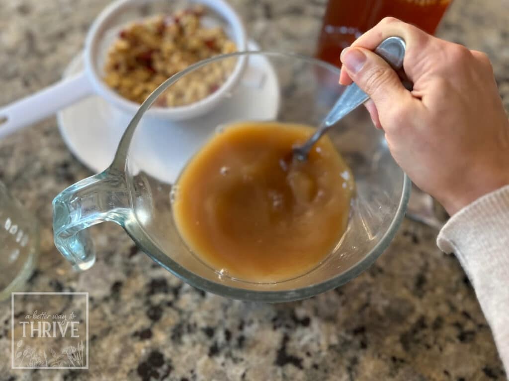 Stirring fire cider to mix vinegar with honey
